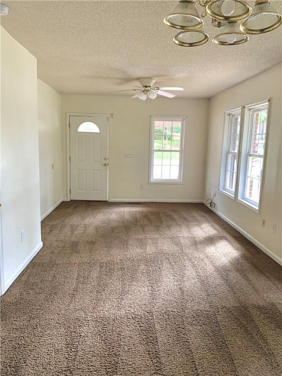 entrance foyer with ceiling fan, carpet, and a textured ceiling