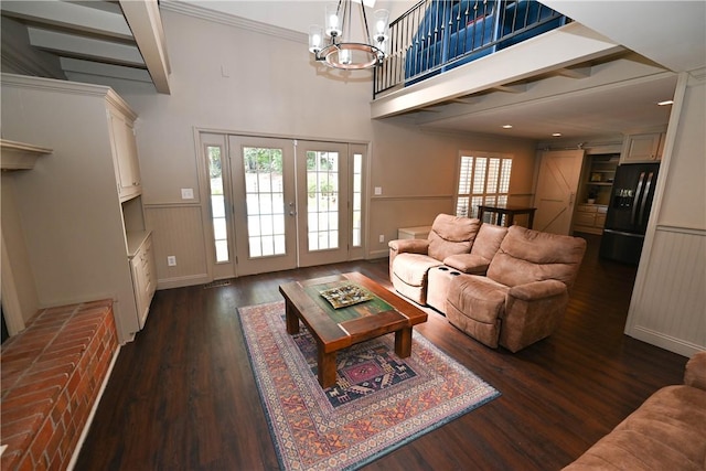 living room with dark hardwood / wood-style flooring, a barn door, an inviting chandelier, and french doors