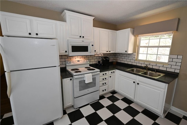 1900 Wrights Mill Rd, Auburn, AL 36830 - kitchen with white appliances, tile patterned floors, dark countertops, white cabinets, and backsplash