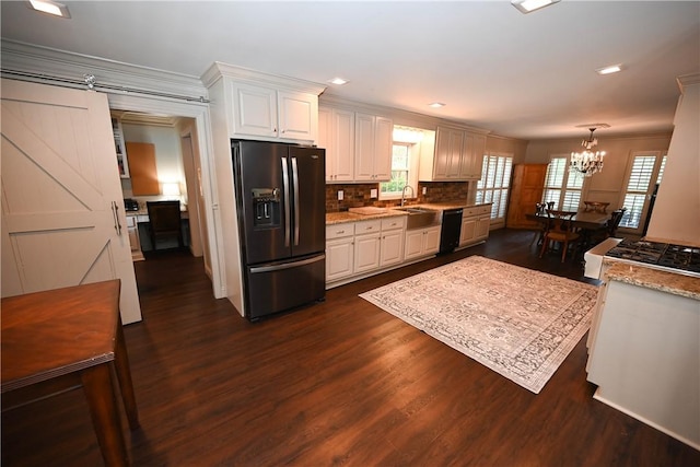 kitchen with dishwasher, white cabinets, sink, stainless steel fridge, and tasteful backsplash