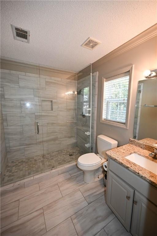 bathroom with walk in shower, ornamental molding, vanity, a textured ceiling, and toilet