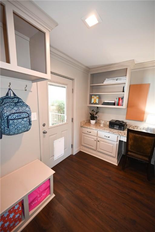 mudroom featuring crown molding, dark hardwood / wood-style flooring, and built in desk