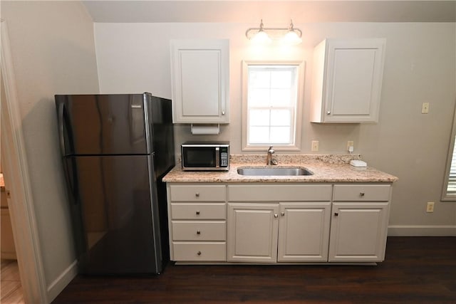 1900 Wrights Mill Rd, Auburn, AL 36830 - kitchen featuring freestanding refrigerator, stainless steel microwave, white cabinetry, light stone counters, and dark wood-style floors