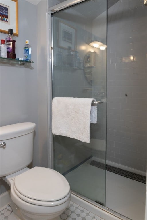 bathroom with toilet and a shower with shower door