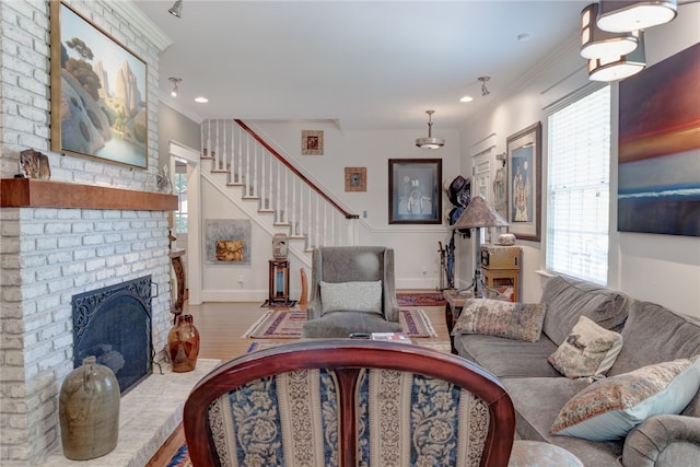 living room featuring crown molding, wood-type flooring, and a brick fireplace