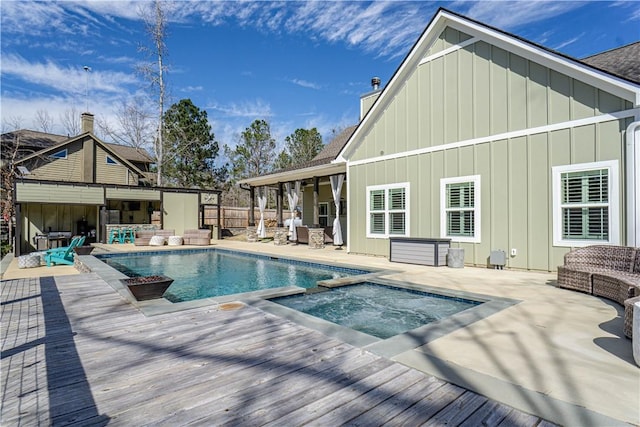 view of pool featuring an outdoor living space, a deck, outdoor dry bar, and a pool with connected hot tub