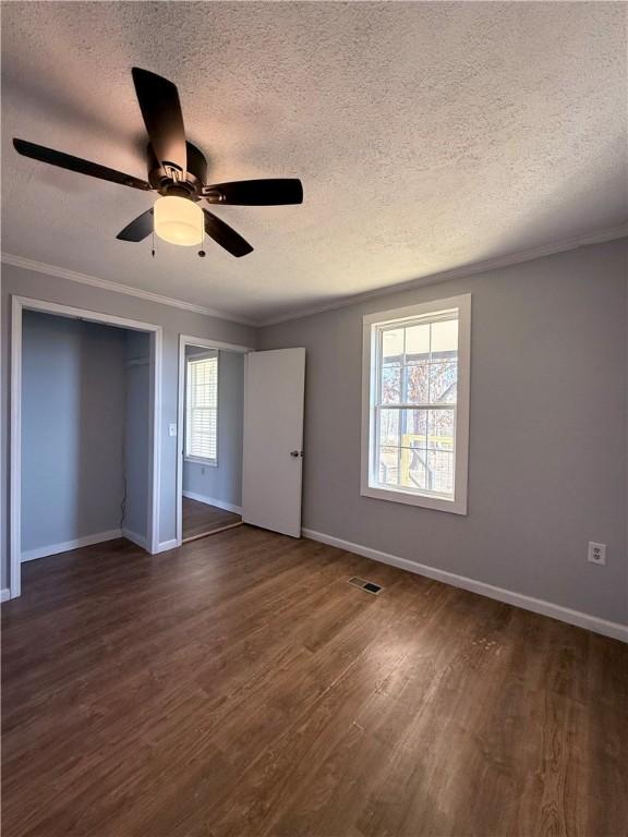 unfurnished bedroom featuring ceiling fan, multiple windows, and a textured ceiling