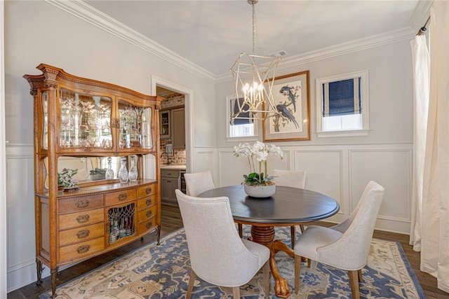 dining area featuring ornamental molding, a decorative wall, and wood finished floors