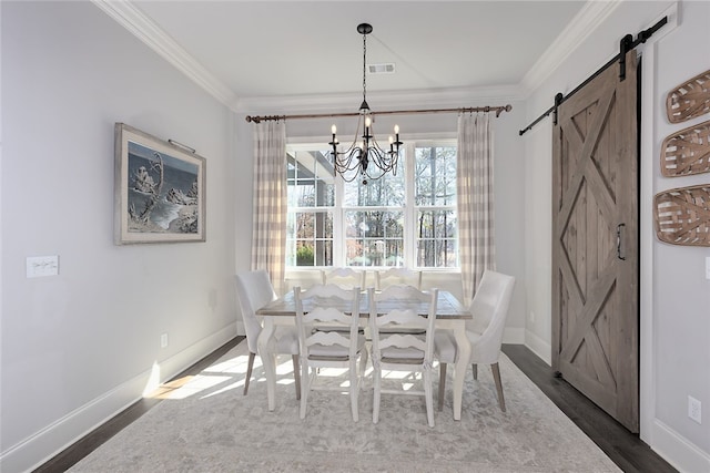 dining room featuring dark wood-style floors, visible vents, a barn door, ornamental molding, and a chandelier