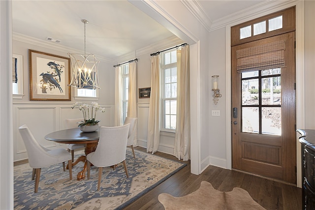 entrance foyer featuring dark wood-type flooring, plenty of natural light, visible vents, and crown molding