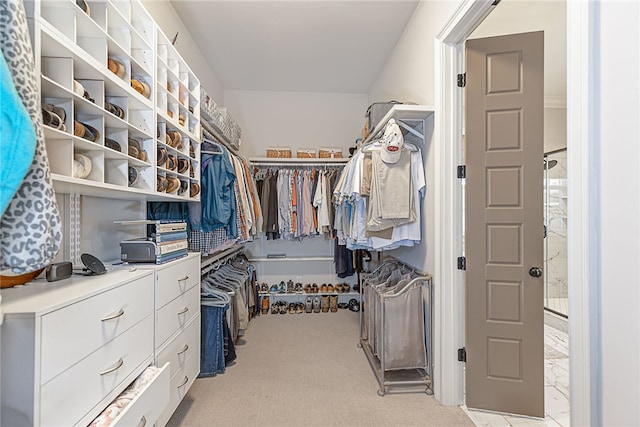 walk in closet featuring light colored carpet