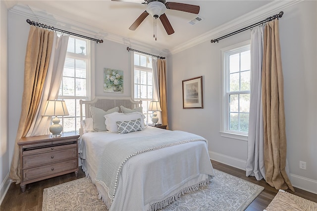 bedroom featuring a ceiling fan, visible vents, baseboards, ornamental molding, and dark wood-style floors