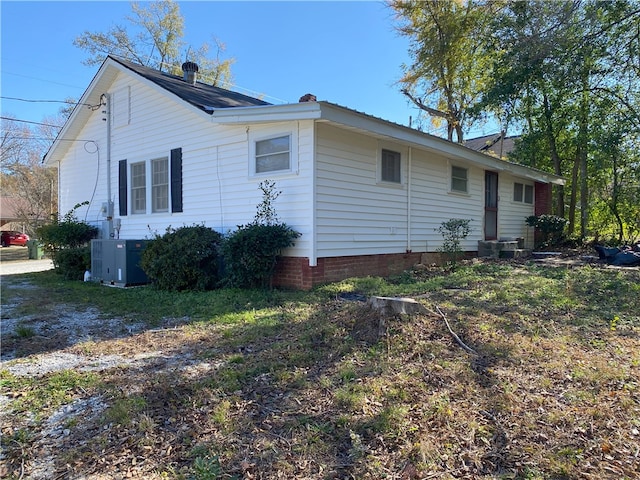 view of side of home with central AC