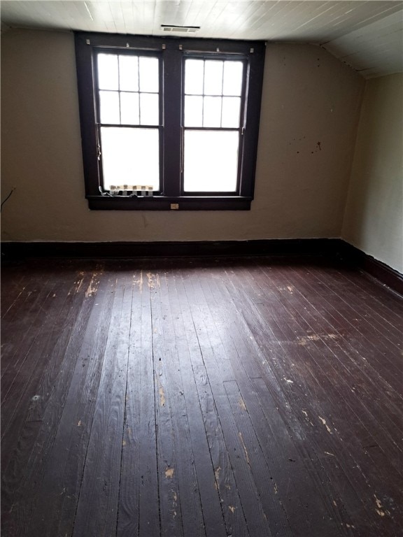 interior space featuring baseboards, vaulted ceiling, and hardwood / wood-style floors