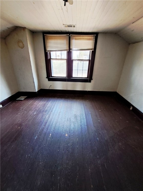 additional living space featuring vaulted ceiling, hardwood / wood-style floors, visible vents, and baseboards