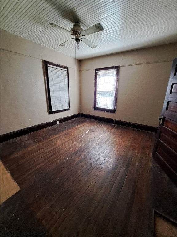 interior space with baseboards, dark wood finished floors, and a ceiling fan