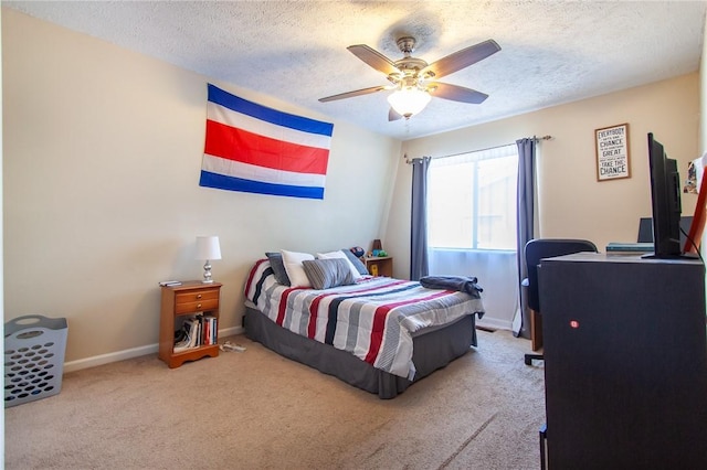 carpeted bedroom featuring ceiling fan, baseboards, and a textured ceiling