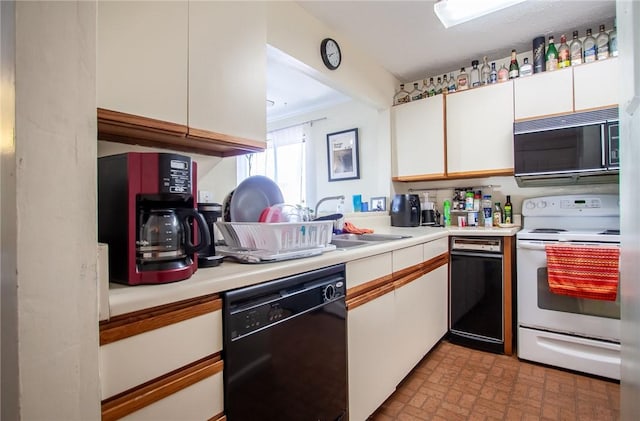 kitchen with white cabinets, black appliances, light countertops, and brick patterned floor