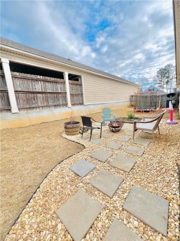 view of patio / terrace featuring a trampoline and an outdoor fire pit