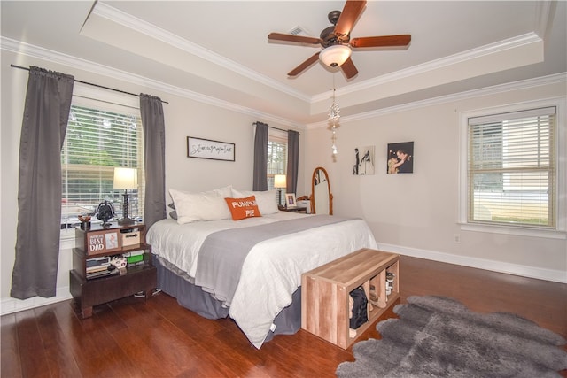 bedroom featuring a raised ceiling, crown molding, and dark hardwood / wood-style flooring