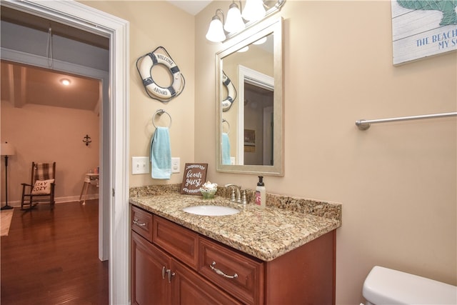 bathroom featuring vanity, hardwood / wood-style flooring, and toilet