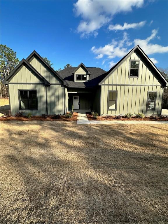 view of front facade with board and batten siding and roof with shingles