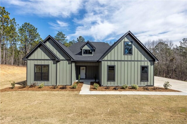 modern inspired farmhouse with a front lawn, board and batten siding, and a shingled roof