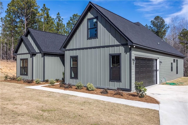 view of front of house with a garage, roof with shingles, board and batten siding, and driveway