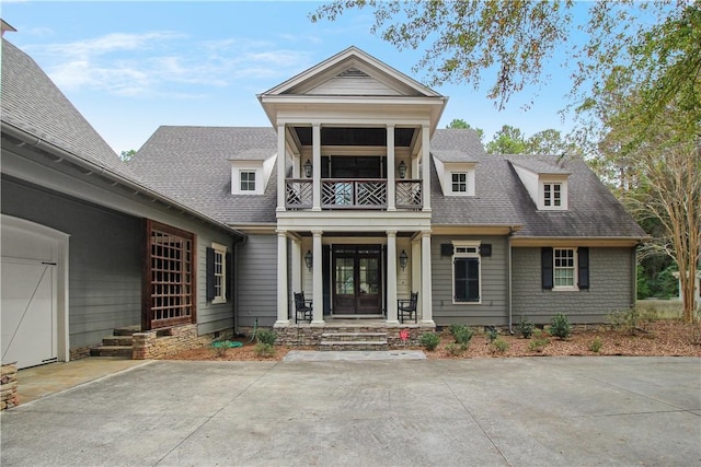 view of front facade featuring a balcony and french doors