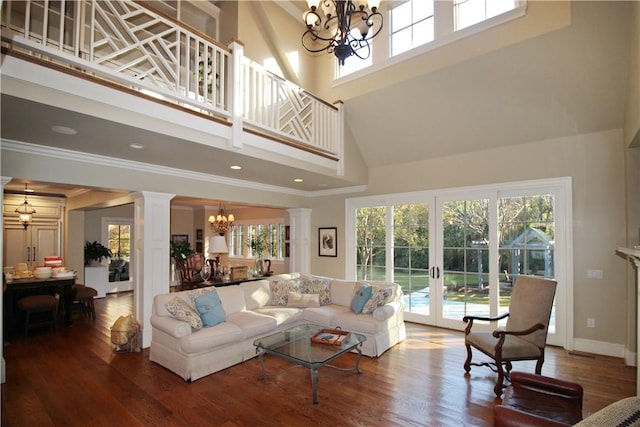 living room with decorative columns, french doors, a chandelier, and a high ceiling