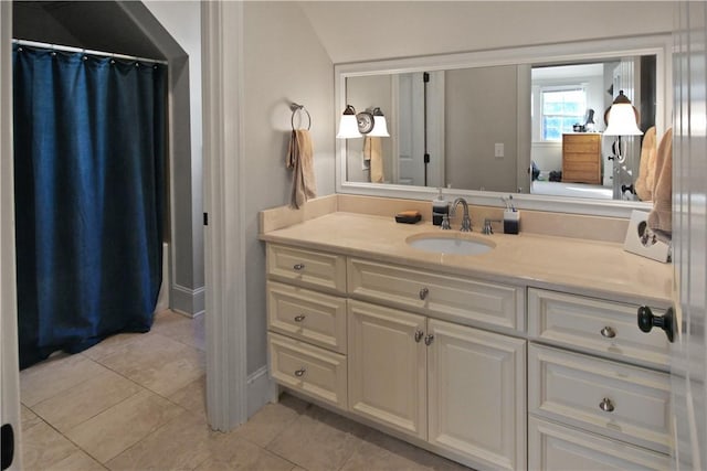 bathroom with tile patterned floors, vanity, and vaulted ceiling