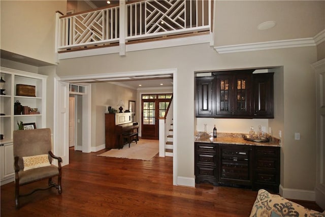 bar with dark brown cabinets, french doors, ornamental molding, and dark wood-type flooring