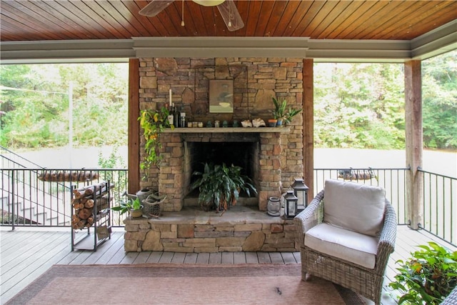 sunroom / solarium featuring a healthy amount of sunlight and an outdoor stone fireplace