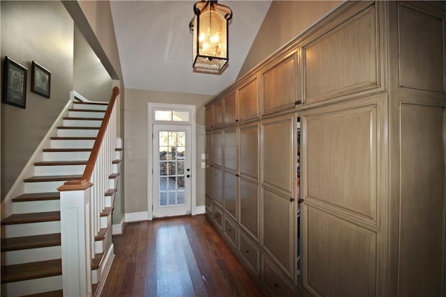 entryway with dark hardwood / wood-style flooring and lofted ceiling