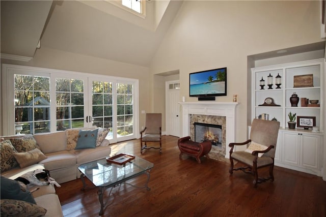 living room featuring a high end fireplace, dark hardwood / wood-style flooring, and high vaulted ceiling