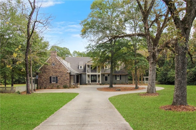 view of front of house featuring a balcony and a front lawn