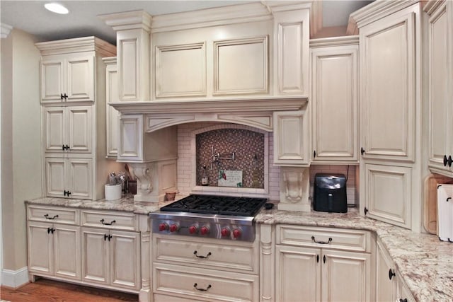 kitchen featuring stainless steel gas cooktop, tasteful backsplash, light stone counters, dark hardwood / wood-style floors, and custom exhaust hood