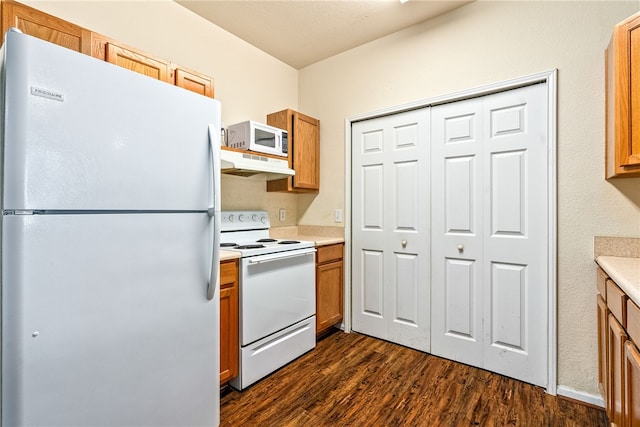 447 W Longleaf Dr Unit 1007, Auburn, AL 36832 - kitchen with white appliances, under cabinet range hood, dark wood-style flooring, light countertops, and brown cabinetry