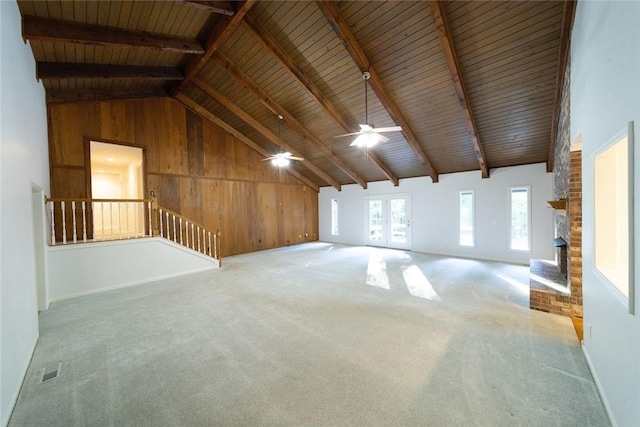 unfurnished living room featuring wood walls, wooden ceiling, beam ceiling, and high vaulted ceiling