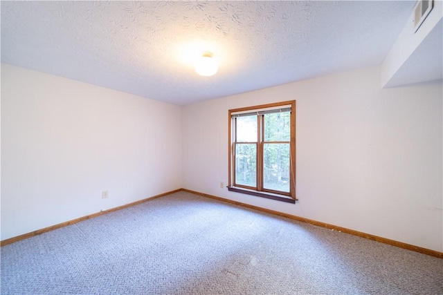 carpeted empty room with a textured ceiling