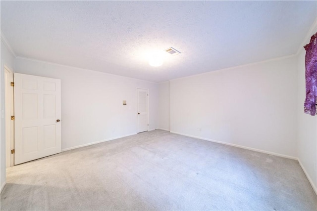 unfurnished room featuring light carpet, a textured ceiling, and ornamental molding