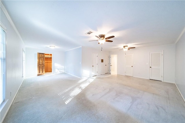 carpeted spare room featuring crown molding and ceiling fan