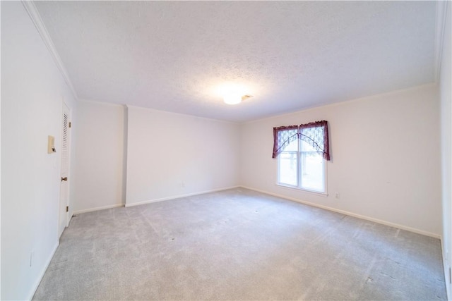 empty room featuring a textured ceiling, crown molding, and light carpet