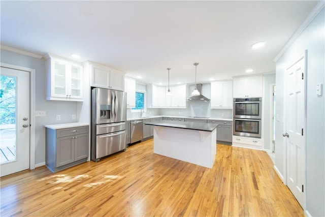 kitchen featuring gray cabinets, white cabinetry, stainless steel appliances, and hanging light fixtures