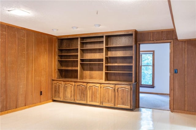 unfurnished living room featuring wooden walls