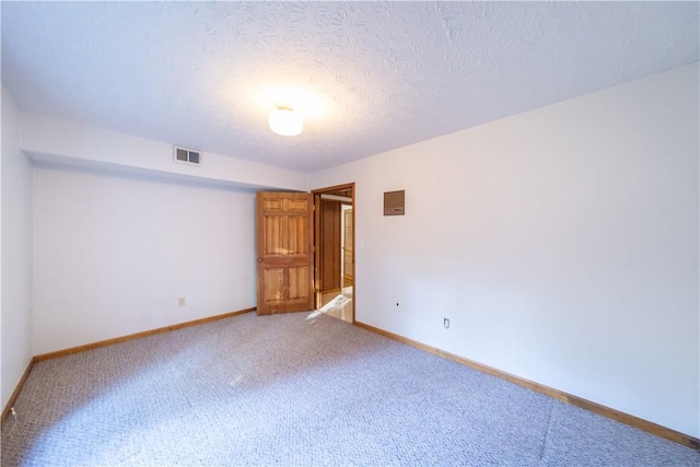 carpeted spare room with a textured ceiling