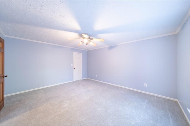 carpeted spare room with ceiling fan, ornamental molding, and a textured ceiling