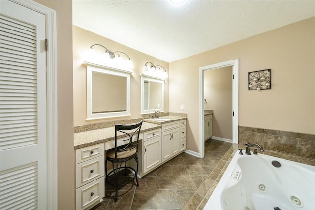 bathroom featuring tile patterned floors, vanity, a bath, and a textured ceiling