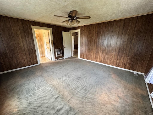 4380 County Road 62, Lafayette, AL 36862 - carpeted spare room featuring a textured ceiling, wood walls, baseboards, a ceiling fan, and heating unit