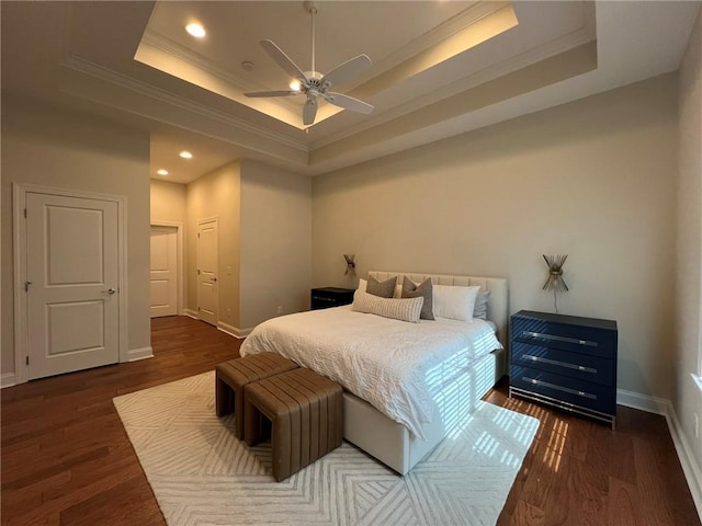 bedroom featuring baseboards, a tray ceiling, recessed lighting, and wood finished floors